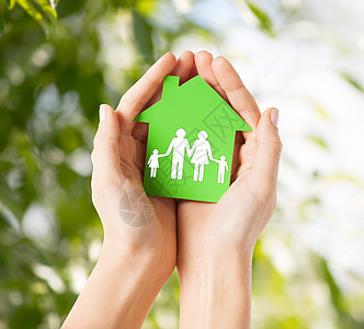 房地产家庭住宅特写图片,女手握绿色纸屋与家庭高清图片