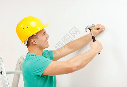 萨比尔,建筑家庭改造的微笑的人黄色防护头盔锤钉墙上图片