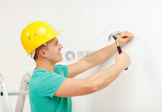 萨比尔,建筑家庭改造的微笑的人黄色防护头盔锤钉墙上图片