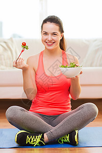 健康,节食,家庭幸福的微笑的运动少女与绿色沙拉家里图片