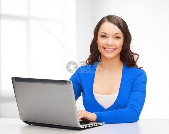 电子小工具微笑的女人穿着蓝色衣服,带着笔记本电脑图片