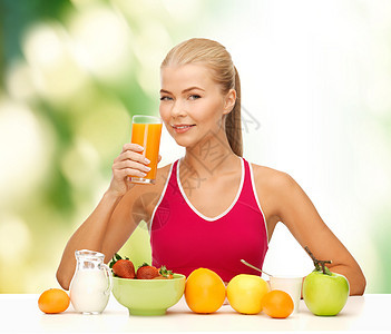 健身,饮食保健微笑的轻妇女健康早餐喝橙汁图片