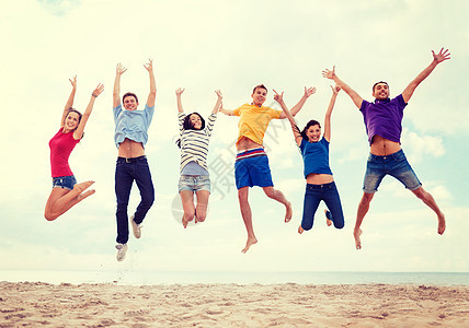 快乐的人群在海滩上跳跃图片