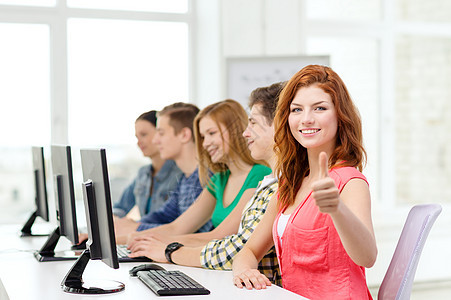 微笑的女学生在学校的计算机课上竖大拇指图片