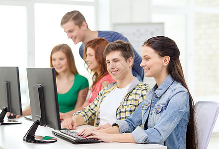 微笑的女学生与同学学校的计算机图片