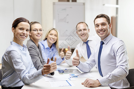 微笑的商业队与平板电脑论文大拇指办公室图片
