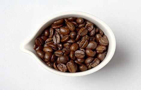 装满哥伦比亚咖啡豆的白瓷杯图片