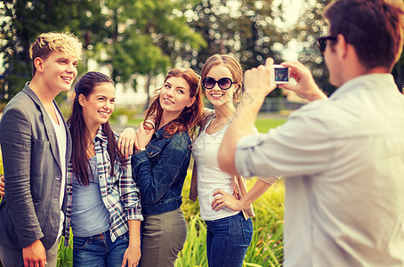 暑假,电子青少群微笑的青少外用数码相机拍照图片