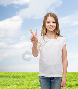 手势快乐的人微笑的小女孩穿着白色空白T恤,用手指表现出平的姿态图片