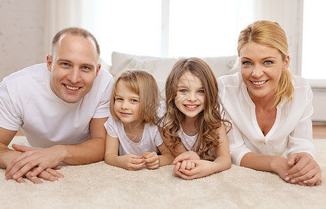 家庭,孩子家庭的微笑的家庭两个小女孩躺家里的地板上图片