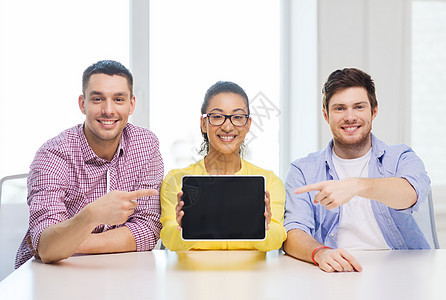 教育技术商业创业办公室理念三位微笑的同事展示平板电脑空白屏幕图片