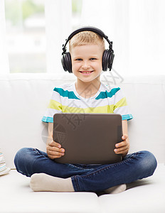 童享好音乐家庭,童,休闲,技术音乐微笑的小男孩与平板电脑耳机家里背景