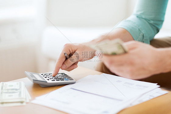 储蓄金融经济家庭用计算器家里数钱笔记的人的特写图片