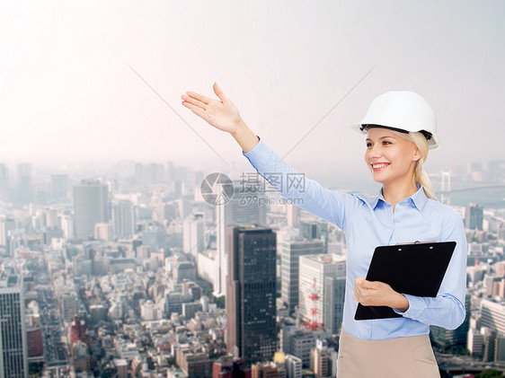 建筑,发展,建筑建筑微笑的女商人戴着白色头盔,剪贴板城市景观背景上图片