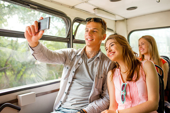 友谊,旅行,暑假,技术人的微笑夫妇与智能手机旅游巴士自拍图片