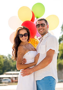粉红气球爱情,婚礼,夏天,约会人们的微笑的夫妇戴着太阳镜,公园里拥抱气球背景