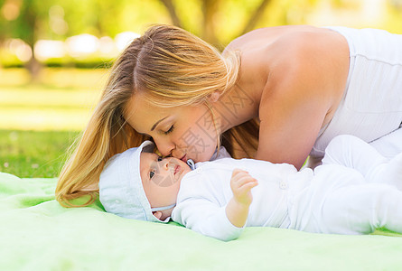 家庭,孩子父母的快乐的母亲躺公园的毯子上小婴儿图片
