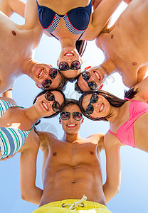 友谊,幸福,暑假,假期人们的群微笑的朋友穿着泳装站蓝天上的圆圈里图片