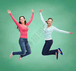 幸福自由友谊教育人的微笑的轻女绿色的木板背景下空中跳跃图片