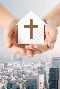 宗教,基督教慈善近距离的妇女手纸屋与基督教交叉象征的城市背景图片