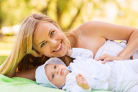家庭,孩子父母的快乐的母亲躺公园的毯子上小婴儿图片