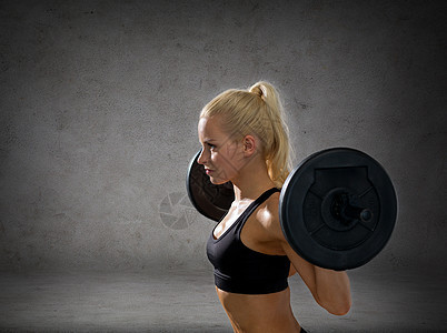 健身,运动节食的运动的妇女运动与杠铃混凝土墙壁背景图片
