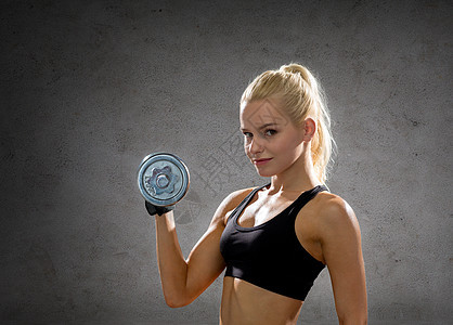 健身,运动,锻炼人的运动的女人与沉重的钢哑铃混凝土墙壁背景图片