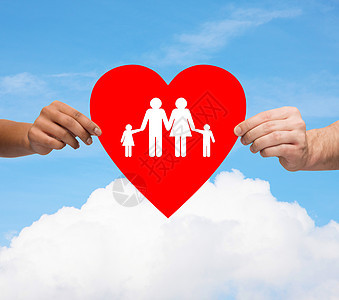 健康,爱,收养关系的特写多种族夫妇的手大红心与家人孩子蓝天白云背景图片