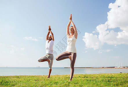 健身,运动,友谊生活方式的微笑的夫妇户外瑜伽练图片