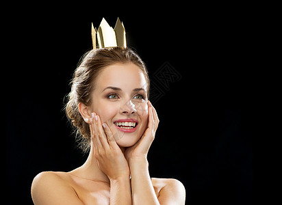 人,假日,皇室魅力的笑的女人戴着金色的皇冠黑色背景图片