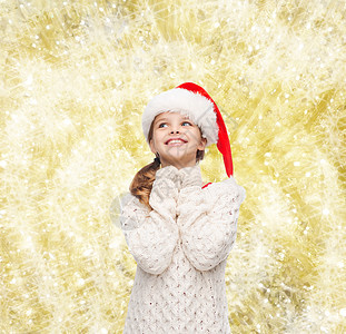 诞节,假日,童人的微笑的女孩诞老人帮助帽子上的黄色灯光背景图片