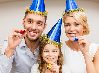 庆祝,家庭,节日生日的三个微笑的女人戴着蓝色的帽子,着爱的号角图片