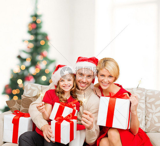 家庭,诞节,幸福人的微笑的家庭诞老人助手帽子与许多礼品盒孟加拉灯图片