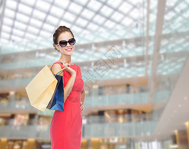 购物,销售,诞节假日微笑优雅的女人穿着红色连衣裙太阳镜带购物袋图片
