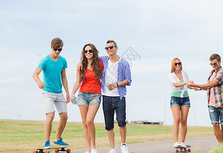 假期,爱友谊的群微笑的青少户外散步骑滑板图片