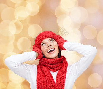 幸福,寒假,诞节人们的微笑的轻女人戴着红色的帽子,围巾手套米灯光背景图片