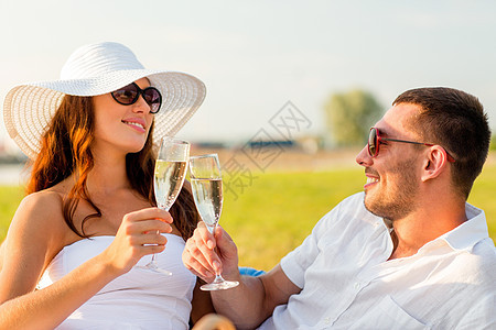 爱情,约会,人假期的微笑的夫妇野餐时喝香槟图片