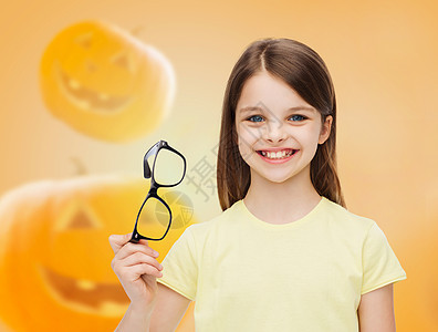 教育,假期,童,视觉人的微笑的小女孩戴着眼镜万节南瓜背景图片