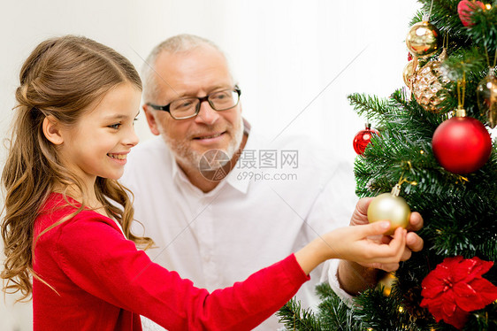 家庭,假期,世代人的微笑的女孩与祖父装饰诞树家里图片