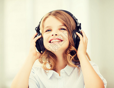 家庭,休闲,新技术音乐微笑的小女孩带着耳机家图片