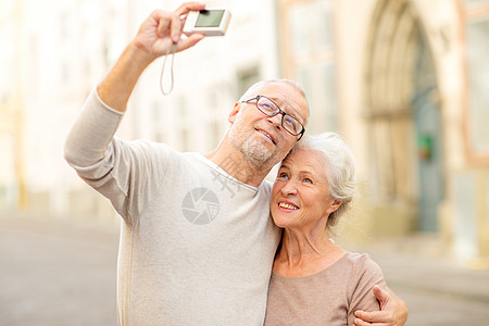 龄,旅游,技术人的老夫妇带着相机街上自拍图片