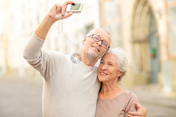 龄,旅游,技术人的老夫妇带着相机街上自拍图片