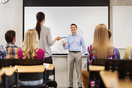 教育,高中,队合作人的微笑老师站白板前学生教室里图片
