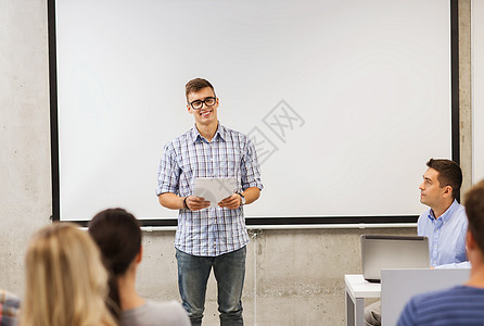 教育,高中,技术人的微笑的学生男孩戴着眼镜,笔记本电脑站学生前,老师教室里图片