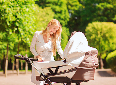 新生儿母亲家庭,孩子父母的快乐的母亲与婴儿车公园背景