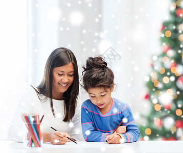 童,家庭,诞节人的微笑的小女孩母亲老师用彩色铅笔室内画画图片