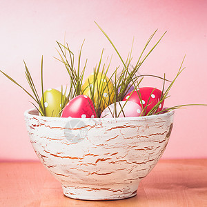 装饰鸡蛋锅与草粉红色的背景复活节装饰图片