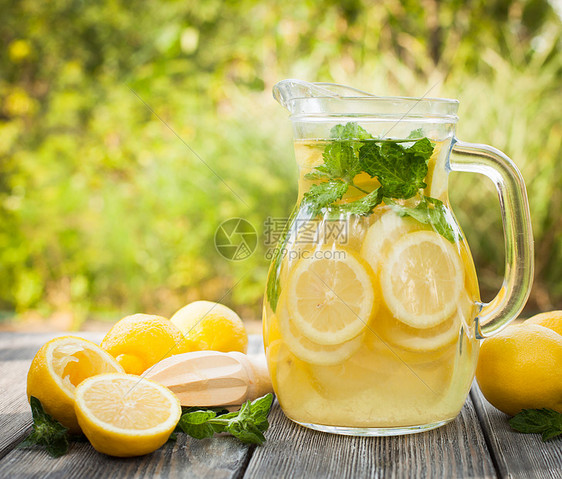柠檬水饮料的准备水壶里的柠檬水户外桌子上的薄荷柠檬图片