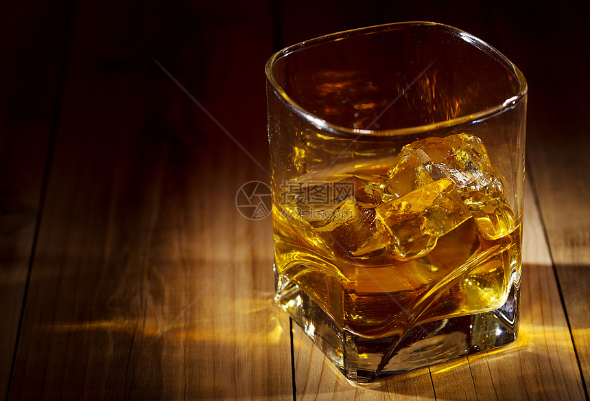 木制桌子上的杯威士忌图片