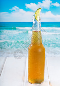 瓶带石灰的啤酒海滩上图片